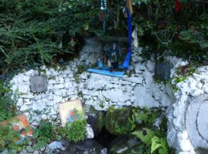 Skour Well at Lough Hyne in Ireland with icons and prayer "rags" hanging from overhangingsacred tree